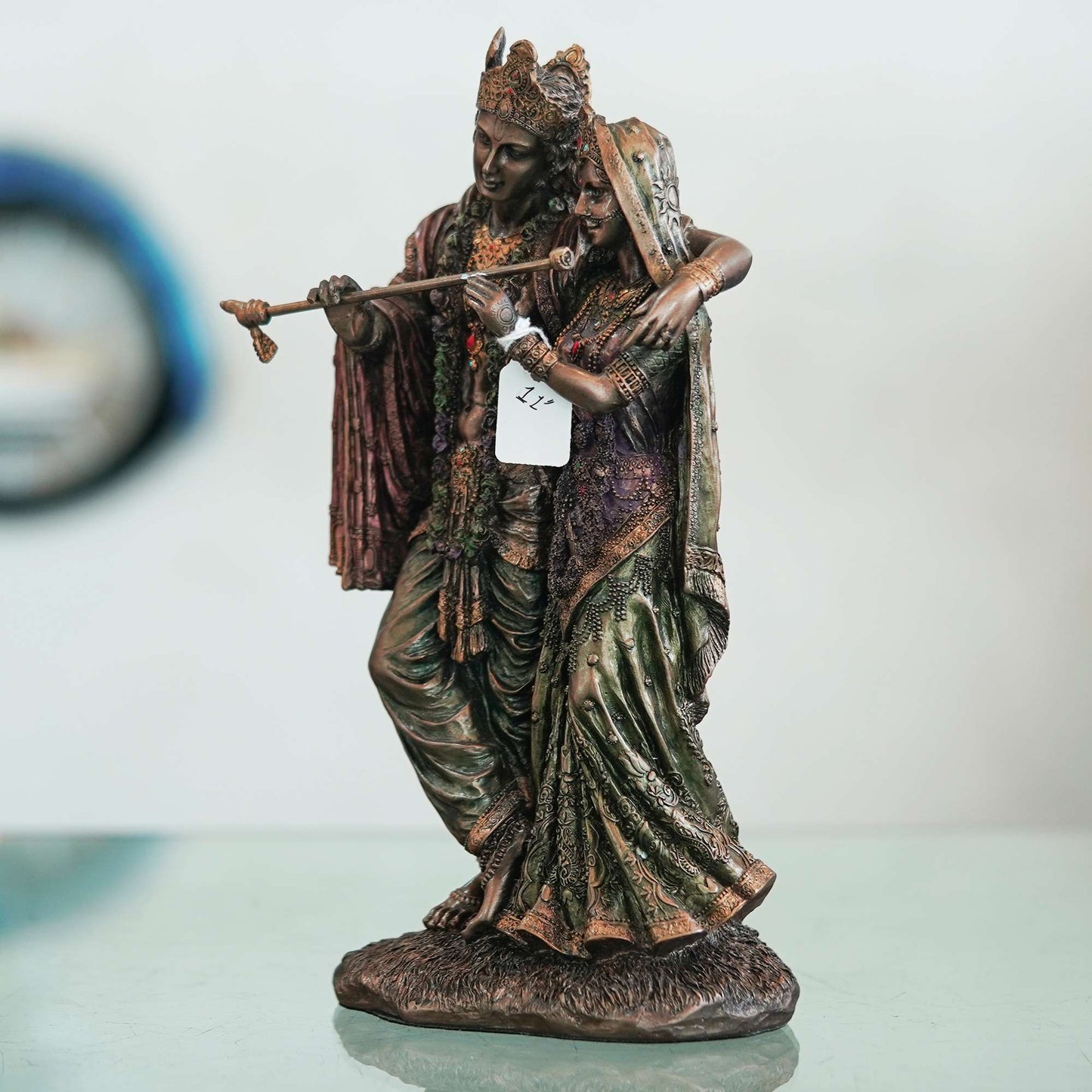 A beautiful and intricate bronze statue depicting Radha and Krishna, two central deities in Hinduism.