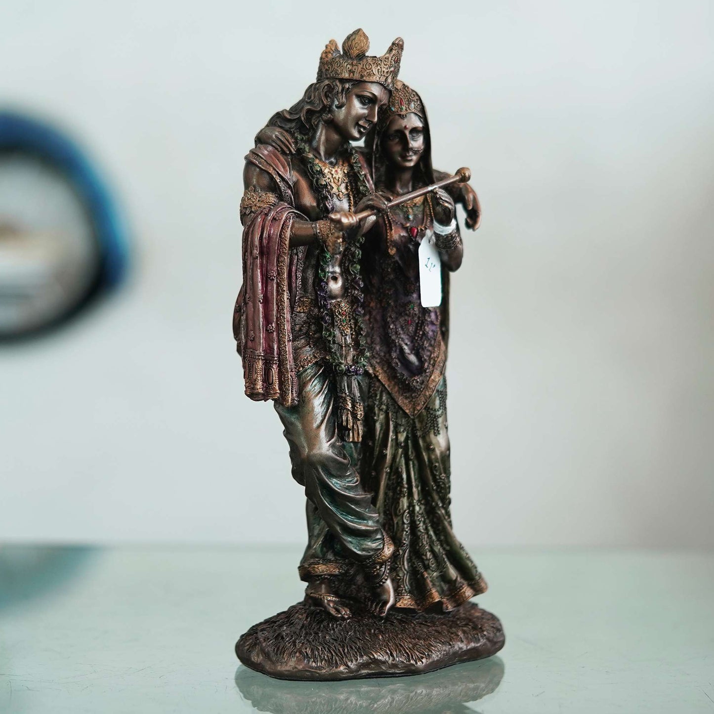 A beautiful and intricate bronze statue depicting Radha and Krishna, two central deities in Hinduism.