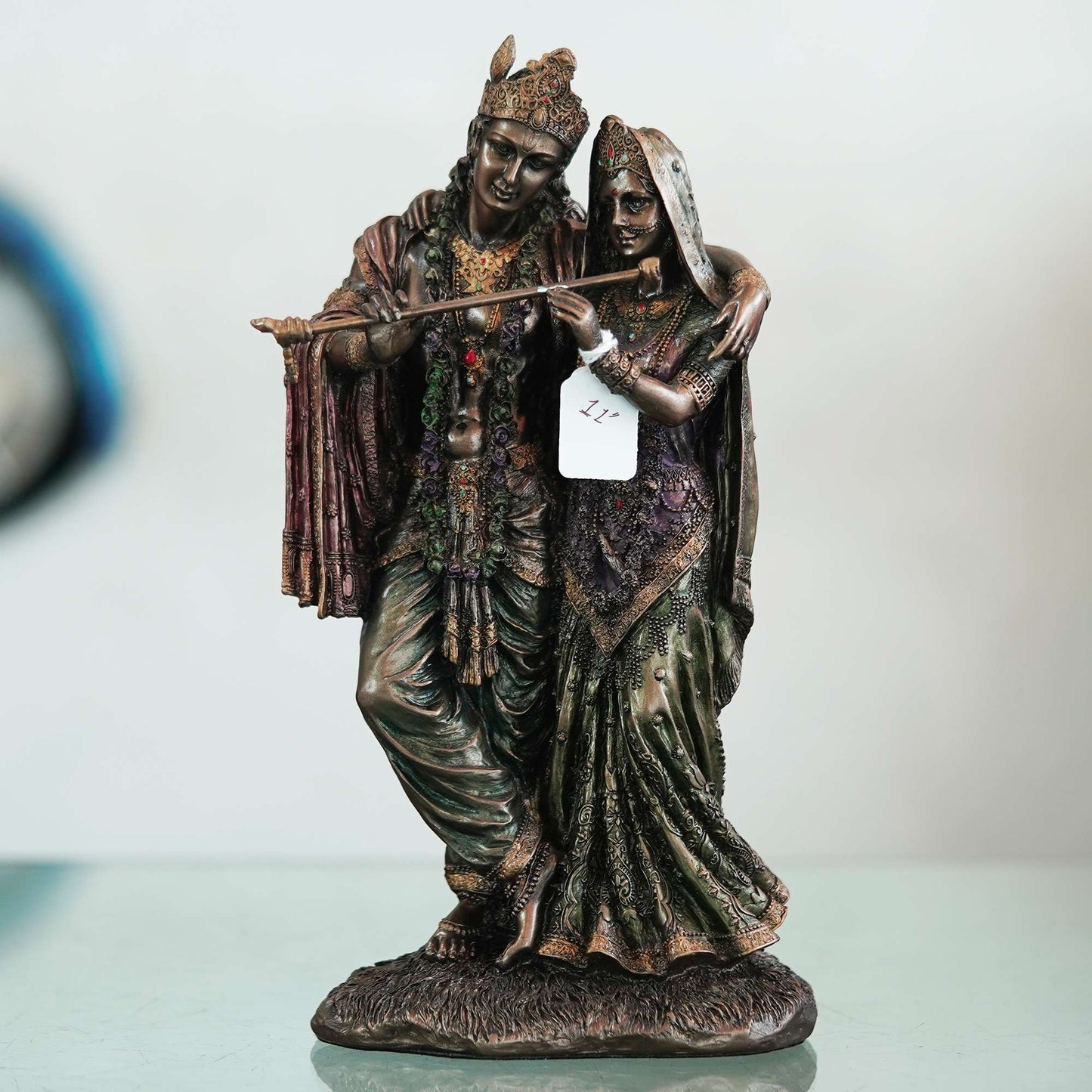 A beautiful and intricate bronze statue depicting Radha and Krishna, two central deities in Hinduism.